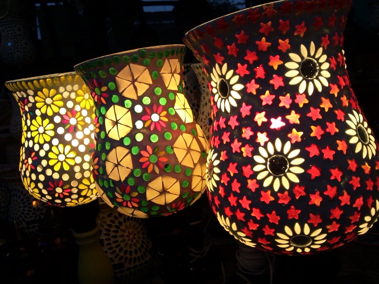 Brightly illuminated mosaic lamps showcasing intricate floral patterns, creating a warm ambiance.